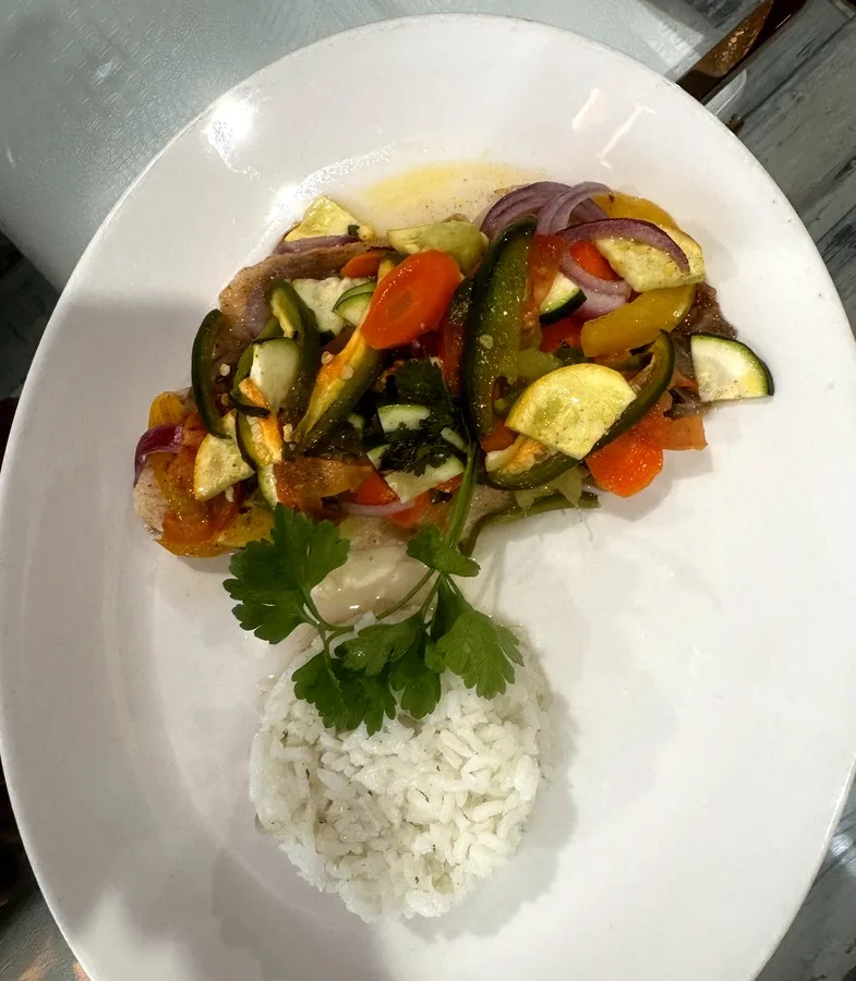 Pescado Jarocho, tilapia topped with zucchini, carrots, onions and peppers with white rice