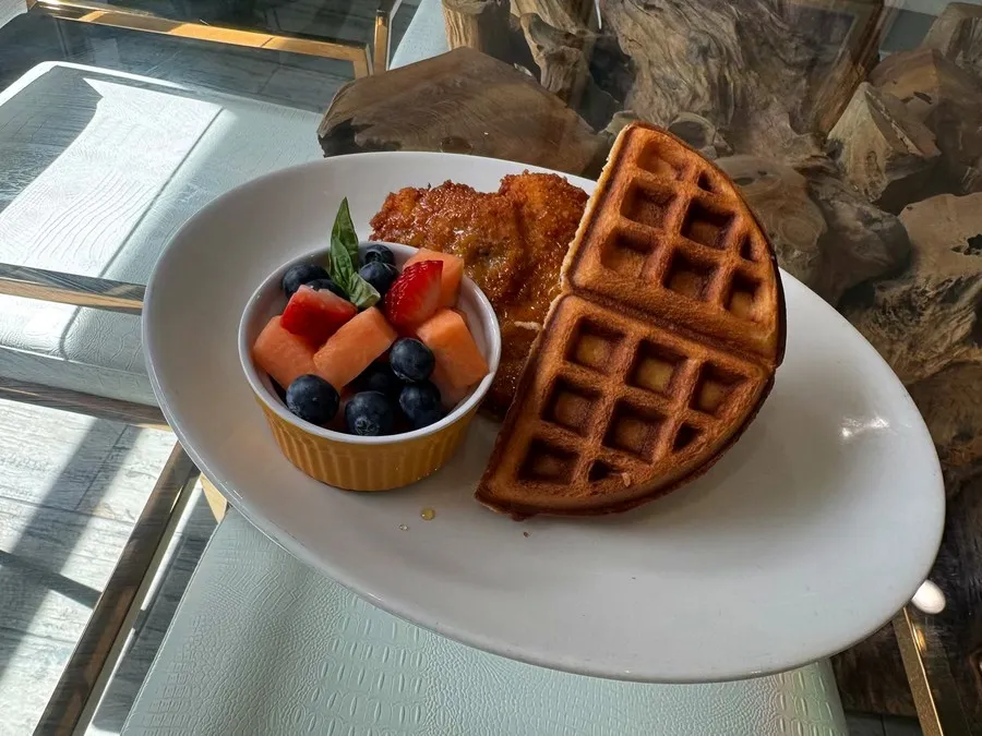 Pollito and Waffle Love, fried chicken and a waffle with a cup of fresh fruit