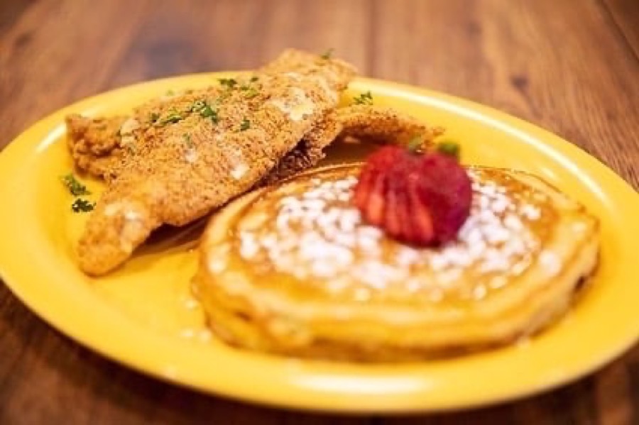 Fried catfish fillet with buttermilk pancakes and a strawberry