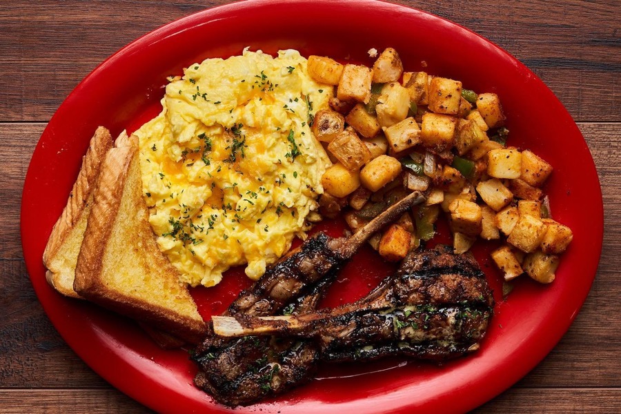 Dream's lamb chops with cheese eggs, potatoes, and Texas toast on a red plate
