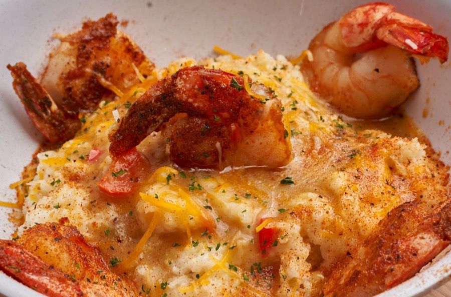 Shrimp and grits topped with Cajun gravy and cheese