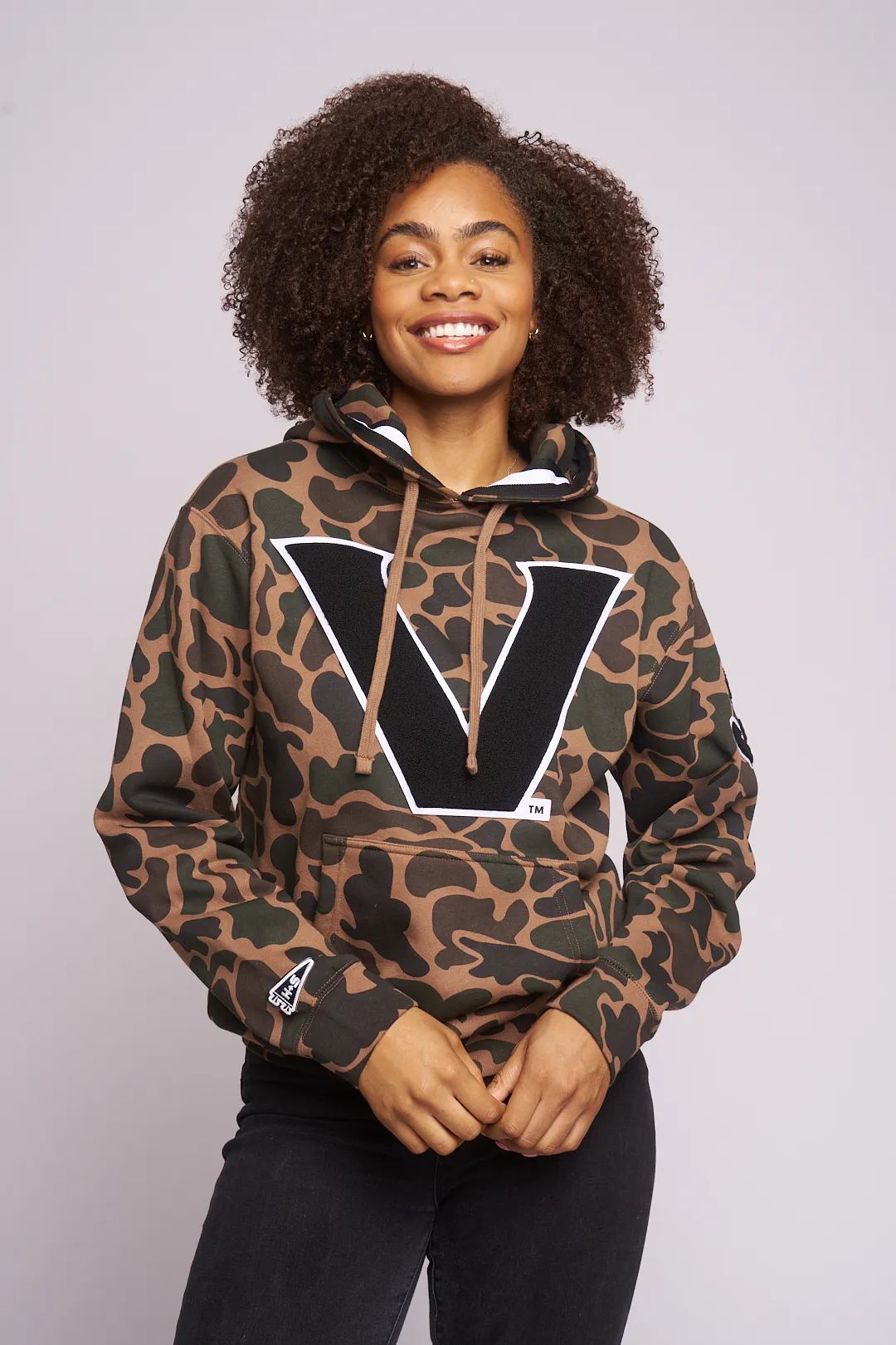 Smiling model in the camo Vanderbilt V hoodie