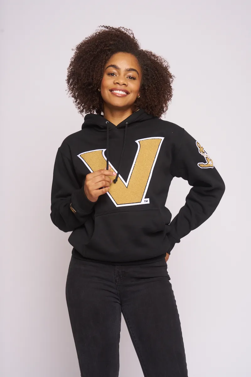 Smiling model in the black and gold Vanderbilt V hoodie