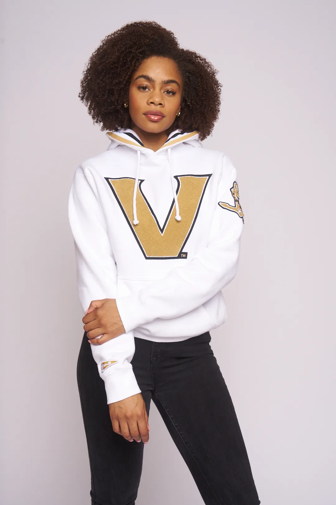 Model in the white Vanderbilt V hoodie, arms crossed